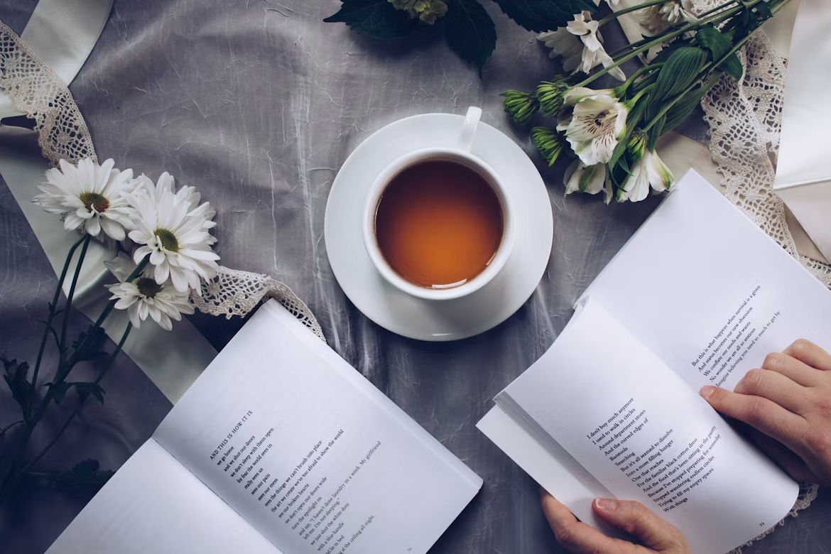 A quiet moment of reflection with tea, an open journal, and soft flowers